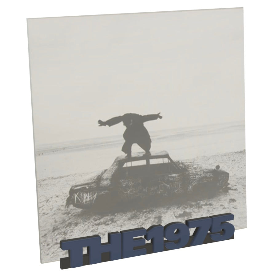 Album cover with a silhouette of a person on a car and 'The 1975' branding.