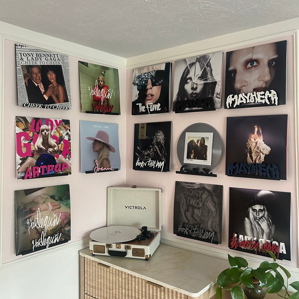 Collection of vinyl records on a wall above a record player.